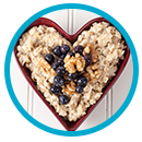 heart-shaped bowl with breakfast of oats and blueberries