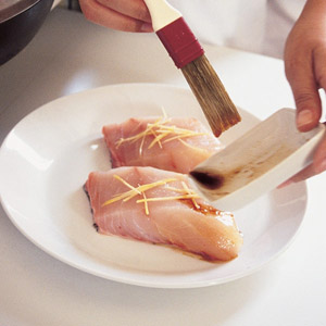 marinating two pieces of white fish on a plate