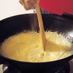stir-frying eggs in a wok