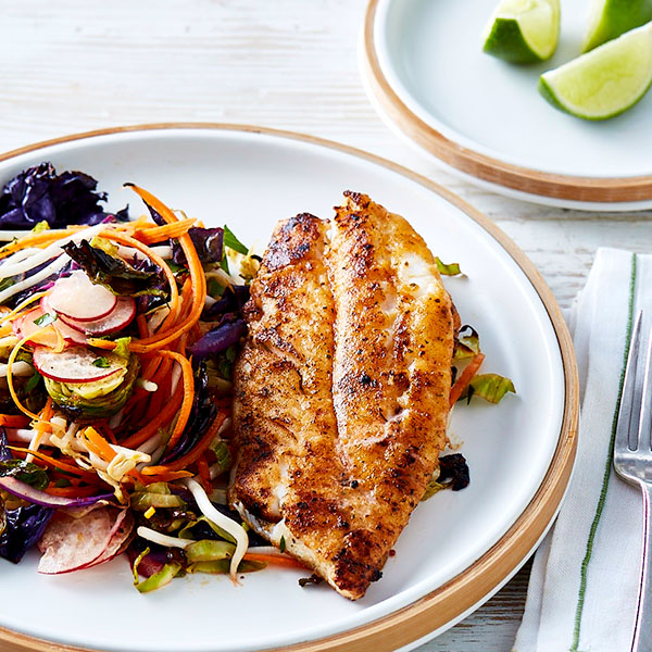 Plate with a slice of barbecued white fish and a simple salad of radish, lettuce, shredded carrots and red onion