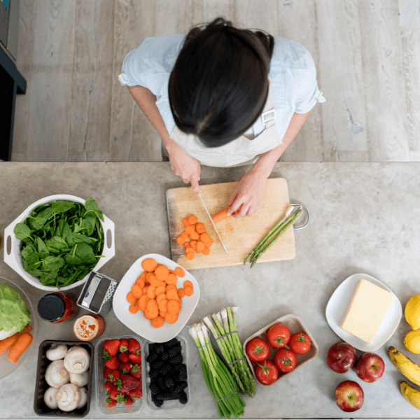 Person preparing fresh seasonal vegetables at home to support healthy eating on a budget.